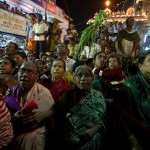 Dewoci patrzą jak jadą wozy kolorowe