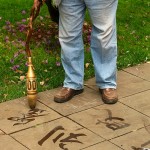 Kunming, Green Lake Park, pan kaligrafuje na chodniku